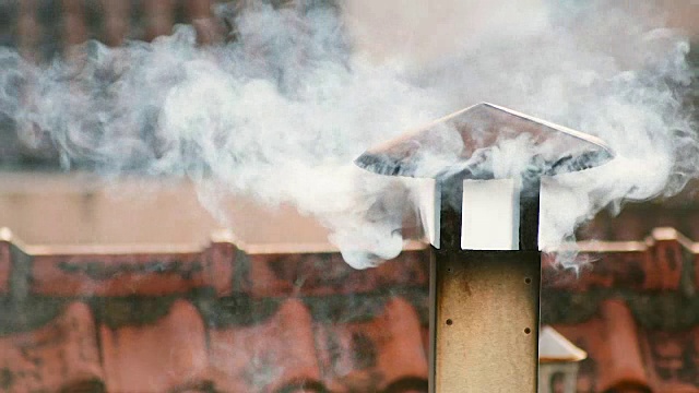 烟从房子的烟囱里冒出来。屋顶上的管子。烟囱。中国的房子。有烟囱的房子。屋顶上的烟视频素材