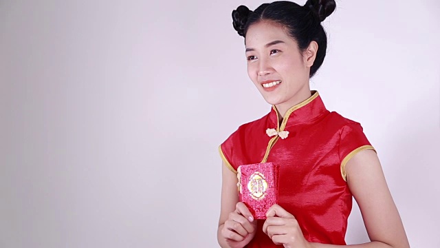 女人穿着旗袍，拿着红包，寓意春节快乐视频下载