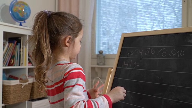 年轻的母亲在家给可爱的小女儿讲解算术视频素材