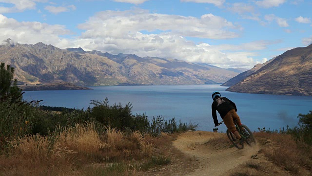 骑山地车的人沿着风景如画的山坡下山视频下载