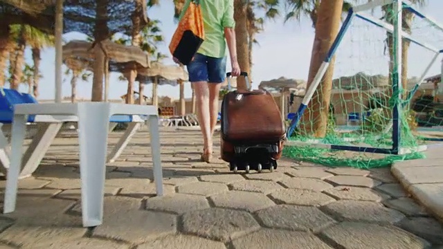 斯坦尼康热女人与旅行袋车轮上是在休闲区视频素材