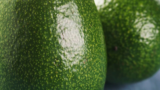 整个成熟的绿色鳄梨放在木桌上视频素材