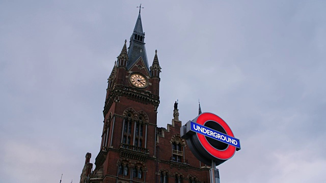 低角度拍摄的圣潘克拉斯酒店与伦敦地铁标志在前景。视频下载