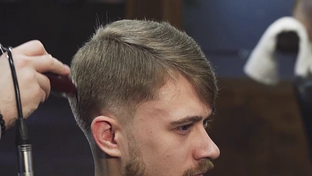 一个英俊的年轻人在理发店理发的特写视频素材