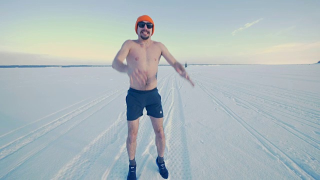 快乐休闲的男人在训练短裤在雪地上跳起来。视频素材