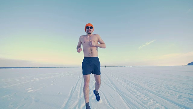 一个跑步者在冬天半裸着练习的正面照片。视频素材