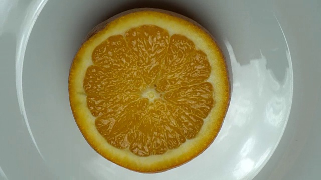 新鲜的橘子在白色的盘子里旋转着。视频素材