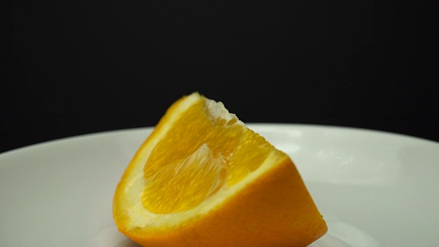 一块新鲜的橘子在白色的盘子上旋转着。视频素材