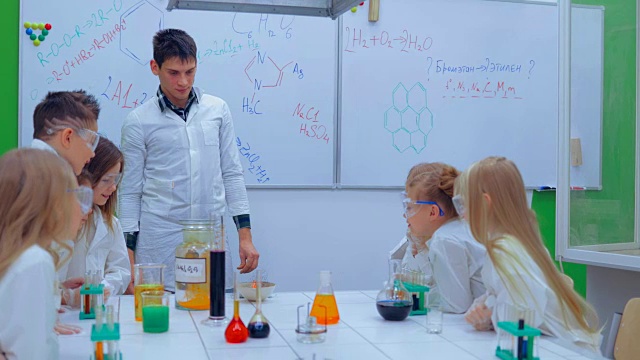 孩子们在学校的实验室里学习化学。老师和小朋友在上化学课视频下载