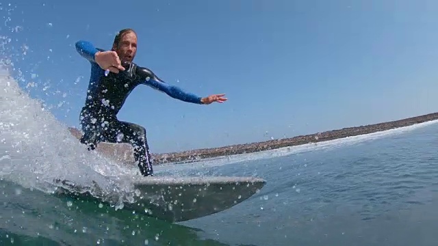 慢动作特写:冲浪者雕刻桶波浪和溅水到相机视频素材
