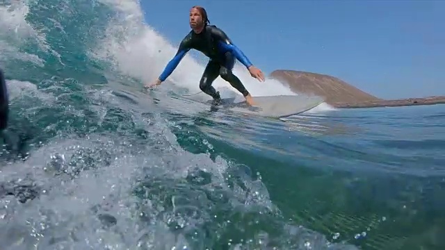 慢动作，水下:水晶清晰的海浪雕刻的专业男性冲浪板视频素材