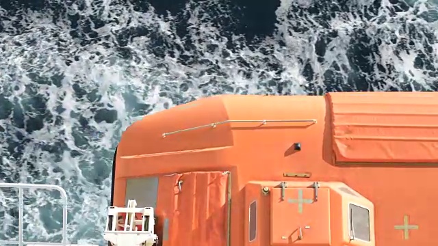 在橙色游轮救生艇下通过海水特写视频视频下载