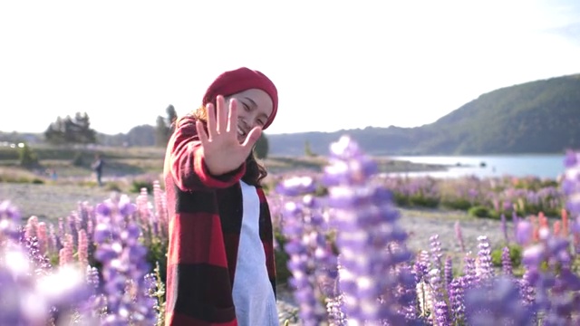 在新西兰，亚洲女人用羽扇花挥手打招呼视频下载