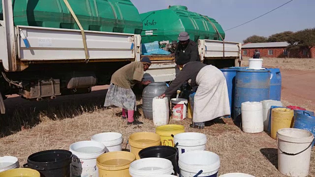由于南非严重的干旱，非洲人用集装箱从水罐车里取水视频下载