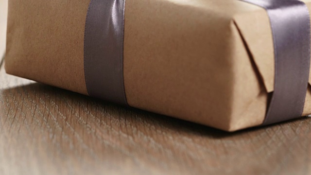 木桌上有淡紫色丝带蝴蝶结的质朴工艺纸制礼品盒视频下载