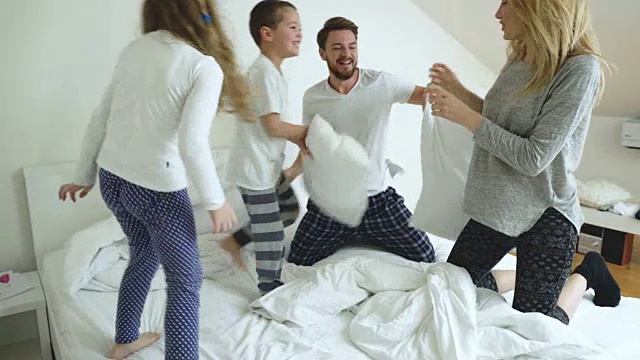 好玩的家庭枕头大战在卧室和在早上有乐趣。视频素材