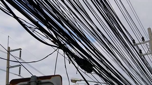 泰国的街道上布满了电线。亚洲的特点。路人头上挂着很多电线视频下载