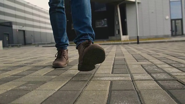 穿鞋的男人走在人行道上的特写镜头视频素材