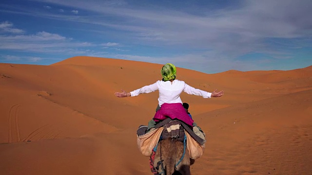 沙漠之旅。女人喜欢骑骆驼视频素材