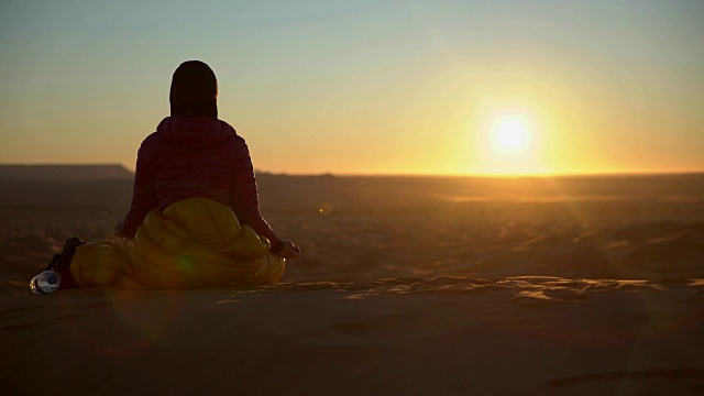 在沙漠日落前沉思的女人视频素材