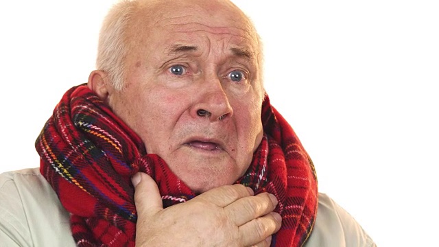 生病的老人戴着围巾咳嗽，看起来很疲惫视频下载
