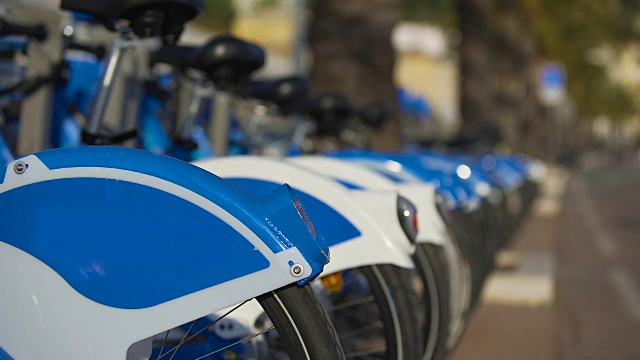 蓝色的生态自行车排在街道上，自行车出租，城市交通视频下载