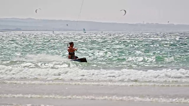 SLO MO风筝滑板沿着海滩在阳光下骑行视频素材