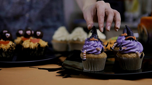 用糖衣帽和腿装饰纸杯蛋糕。松饼像女巫。万圣节的概念视频素材