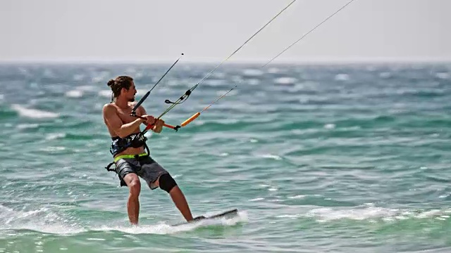SLO MO Man风筝滑板沿着阳光明媚的海岸线视频素材