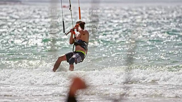 SLO MO风筝滑板跳出水面，在阳光下转弯视频素材