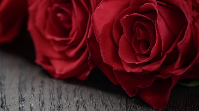 五朵红玫瑰放在木桌上视频下载