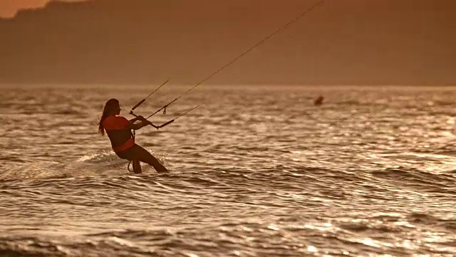 SLO MO女子风筝滑板在日落视频素材