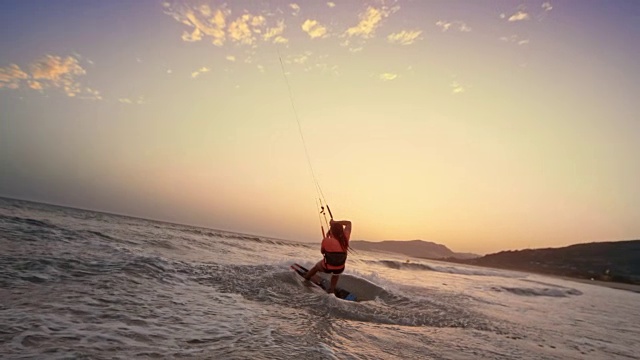 SLO MO女人跳跃与她的风筝板，做一个抓取和微笑在日落视频下载