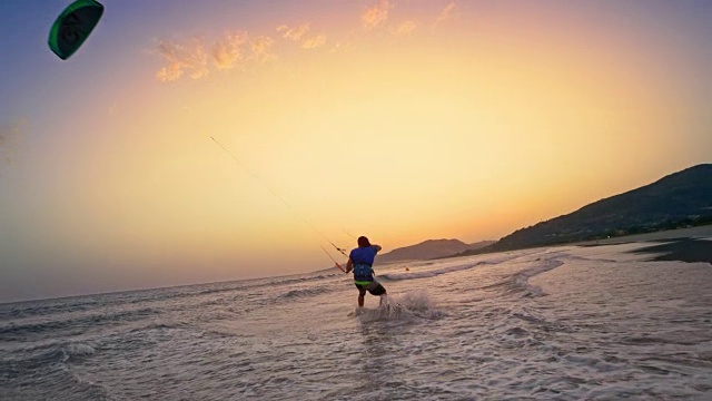 男性风筝滑板者跳上空中，在日落时抓住镜头视频下载