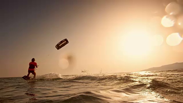 SLO MO女风筝滑板开始在日落的水视频素材