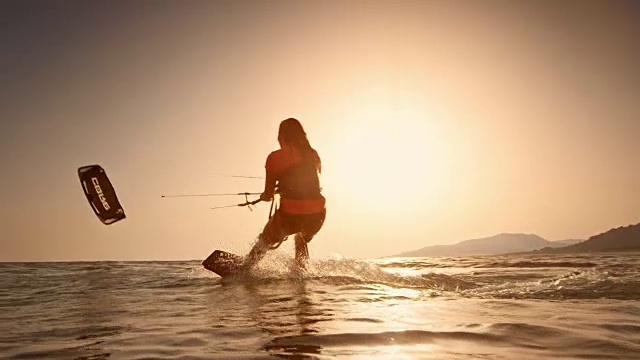 日落时分，女人骑着她的风筝板视频素材