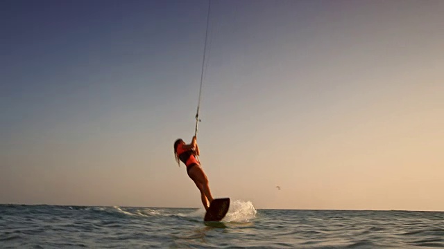 SLO MO女风筝滑板在日落时做一个空中抓取视频素材