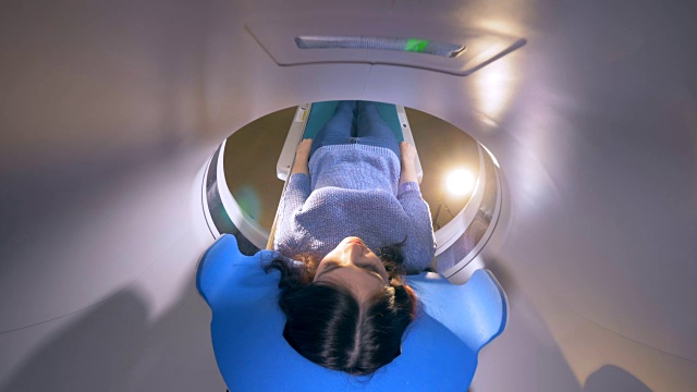 一名年轻女子在一家现代医院接受核磁共振成像扫描。视频素材