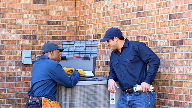 拉丁裔和非裔美国蓝领工人在后院修理空调视频素材