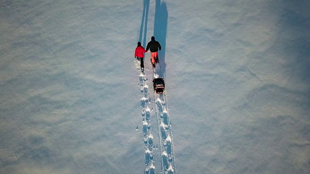 4K鸟瞰图家庭雪鞋户外在冬天日落视频素材