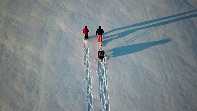 4K鸟瞰图家庭雪鞋户外在冬天日落视频素材