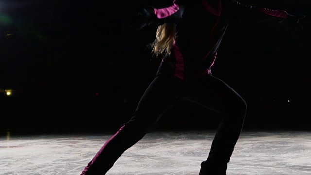 专业的女滑冰运动员穿着冰鞋在冰上滑行，双腿向两侧展开。摄像机也跟着移动。职业滑冰射击延迟视频素材