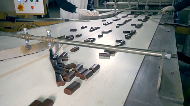 巧克力糖果在被两名工厂工人以近4K的速度分拣后走得更远。视频下载