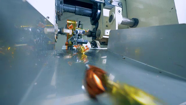 近距离的糖果被一个工作的机器包裹视频素材