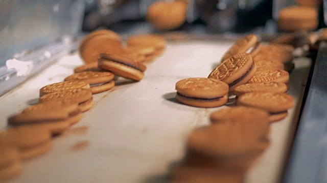 饼干在食品厂的传送带上移动。4 k。视频素材