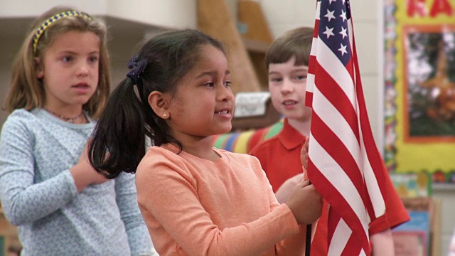 教室里，年轻的学生举着美国国旗，背诵效忠誓词视频下载
