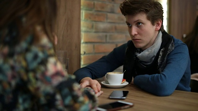一对年轻情侣在咖啡馆调情视频素材