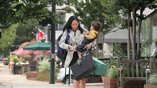 忙碌的工作母亲抱着孩子，杂货，公文包和包寻找汽车钥匙视频下载
