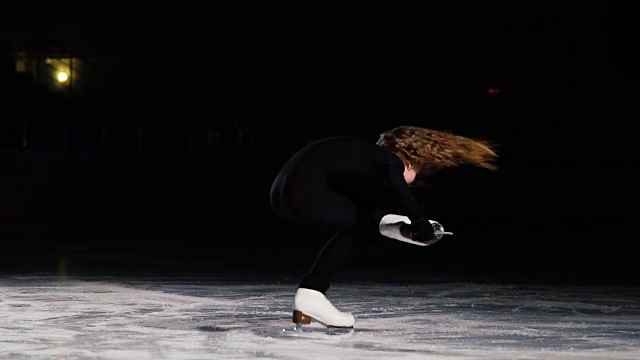 身穿黑色西装的专业花样滑冰运动员在慢动作镜头中展示冰鞋顶端在冰上的力量视频素材