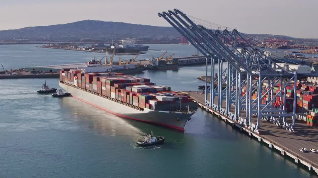拖船操纵大型货船进入码头-无人机射击视频素材